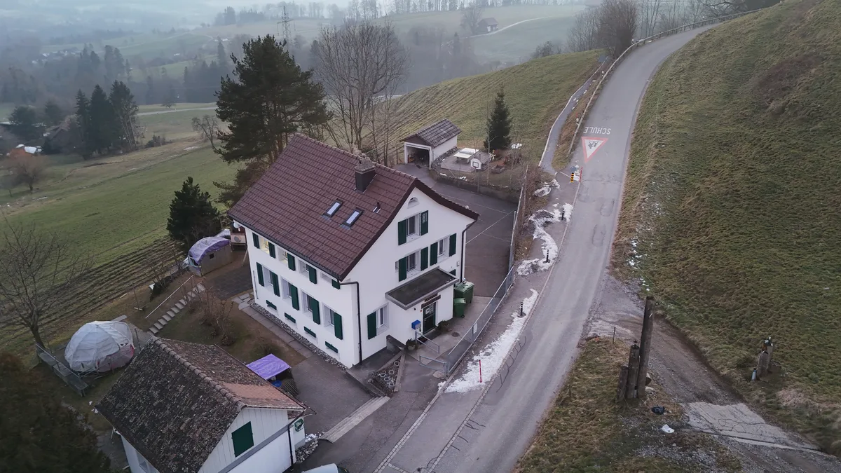 Das Gebäude der Schule Unterbach ist sanierungsbedürftig. Der Schulgemeinde sind die Baumassnahmen aber zu teuer. Luftaufnahme eines Schulhauses.